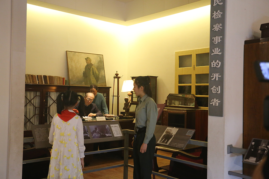 讲解员许雅玲向刘品言介绍罗帅办公室复原陈列场景。图片来源：湖南文明网 记者 彭团 摄