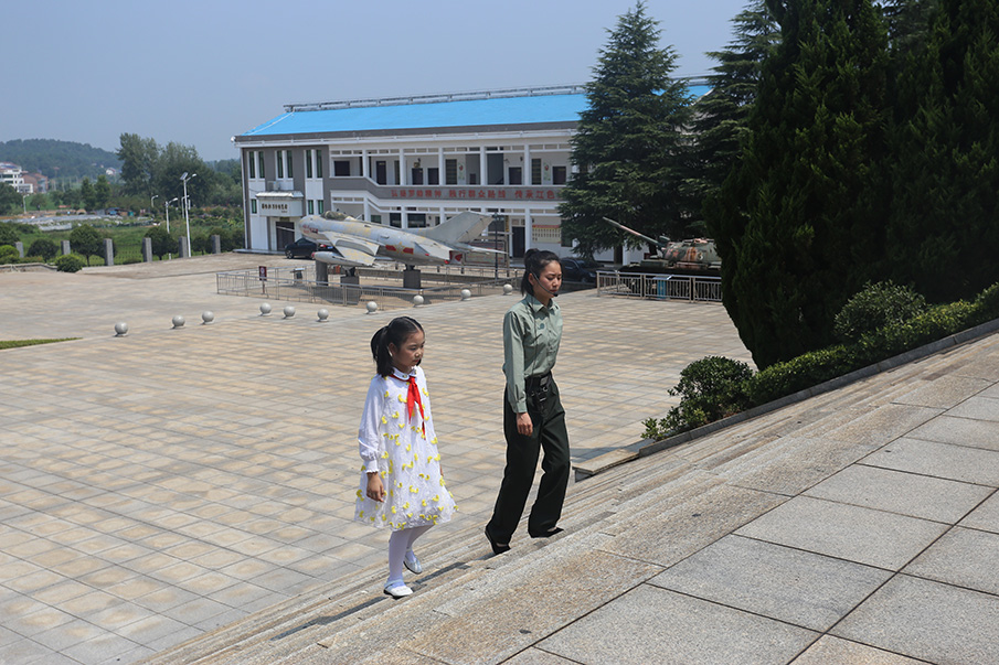 随后，刘品言来到罗荣桓元帅铜像纪念广场，和讲解员许雅玲一起走过196级台阶，瞻仰罗荣桓元帅铜像。图片来源：湖南文明网 记者 彭团 摄