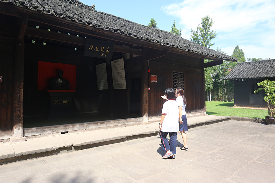刘洋带领向博走进贺龙故居堂屋，故居的上方是邓小平同志亲笔题写的“贺龙故居”牌匾，堂屋置放的是贺龙元帅身穿戎装的半身铜像。图片来源：湖南文明网 记者 彭团 实习生 孙豆豆 摄