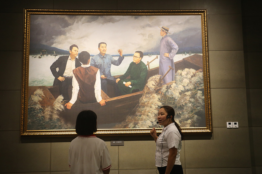 在油画《小船会议》前，刘洋为向博讲述南昌起义前的故事。图片来源：湖南文明网 记者 彭团 实习生 孙豆豆 摄