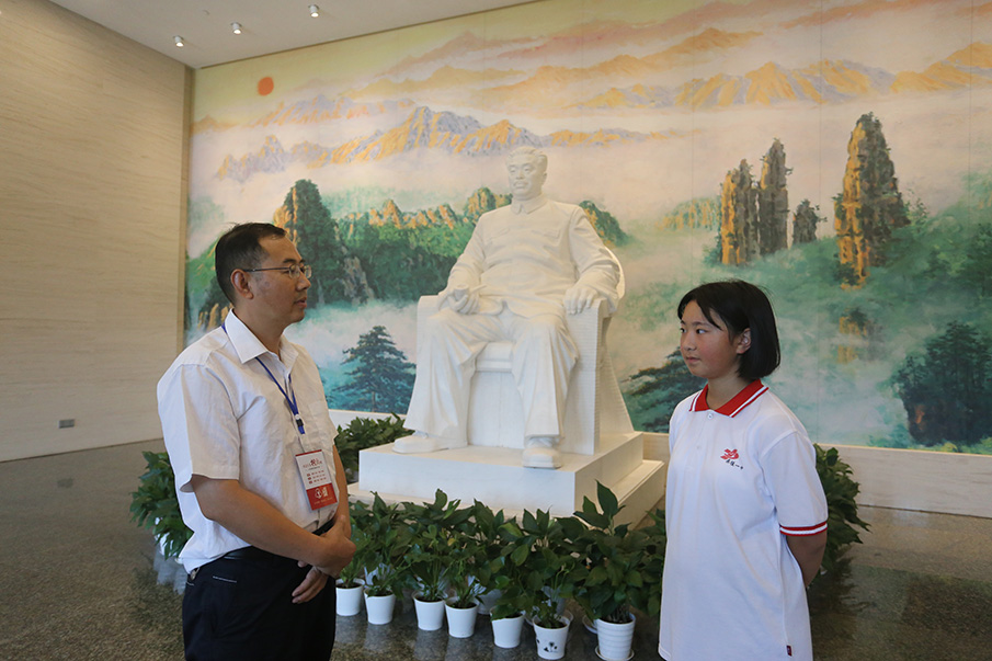 在贺龙纪念馆序厅，贺龙纪念馆馆长幸电安（左一）回答向博提问。图片来源：湖南文明网 记者 彭团 实习生 孙豆豆 摄